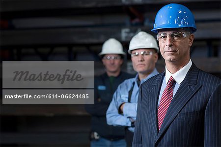 Businessmen standing in metal plant