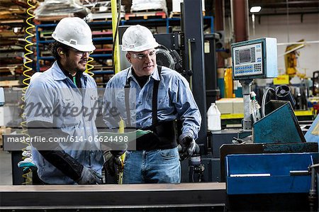 Workers talking in metal plant