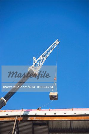 Crane loading equipment on building