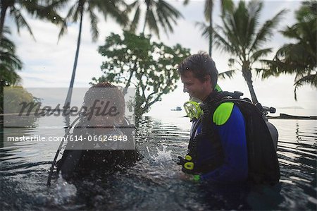 Scuba divers splashing in water