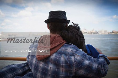 Couple hugging on ferry in urban harbor Couple hugging on ferry in urban harbor