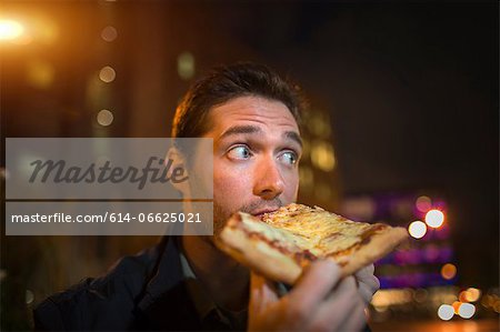 Man eating pizza on city street Man eating pizza on city street