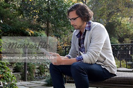 Man using tablet computer outdoors