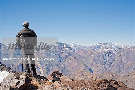 Hiker overlooking snowy mountains Hiker overlooking snowy mountains