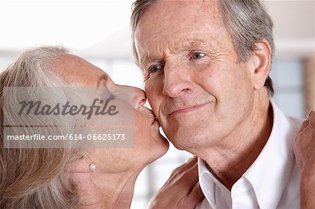 Older woman kissing husband