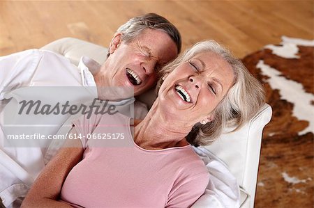 Older couple laughing on sofa