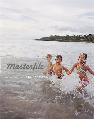 Children playing in waves on beach