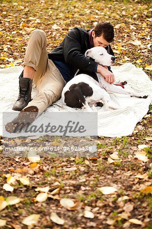 Man and dog relaxing on picnic blanket