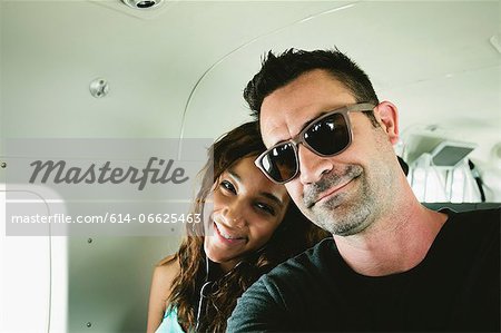 Smiling couple sitting in airplane