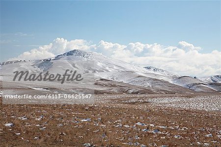 Clouds over hills in snowy landscape