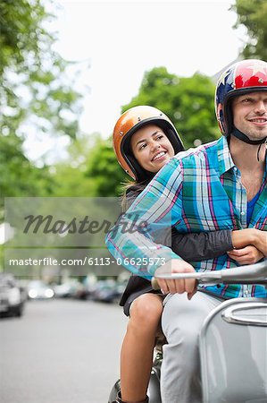 Couple riding scooter together