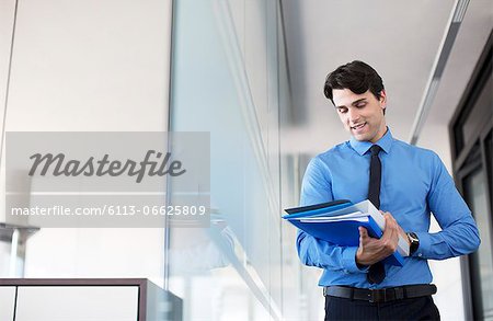 Businessman using digital tablet in office hallway