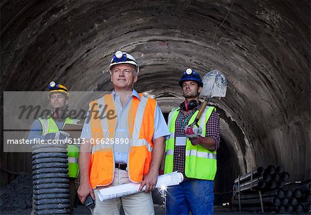 Businessman and workers standing in tunnel