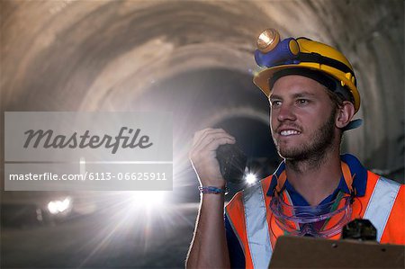 Worker using walkie-talkie in tunnel