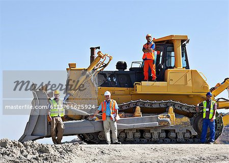 Workers on bulldozer smiling in quarry