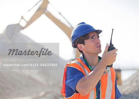 Worker using walkie-talkie in quarry