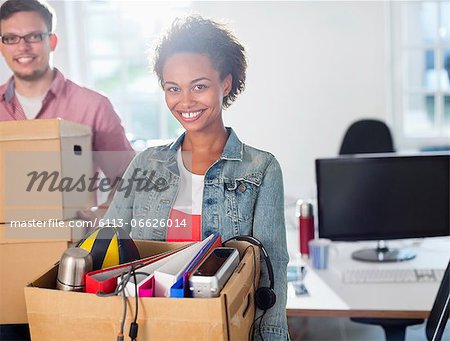 Businesswoman carrying box of belongings