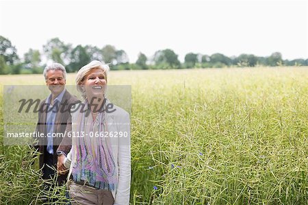 Couple walking in field of tall grass