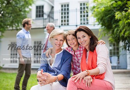 Family smiling together outside house