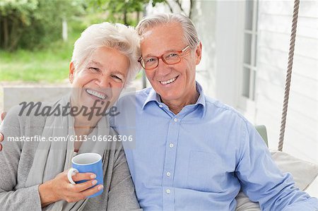 Smiling couple sitting on porch swing