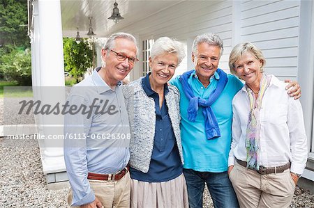 Friends standing together outside house