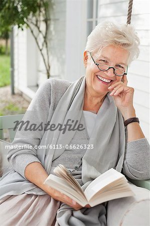 Woman reading book on porch swing