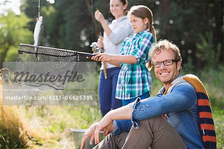 Family fishing together in tall grass