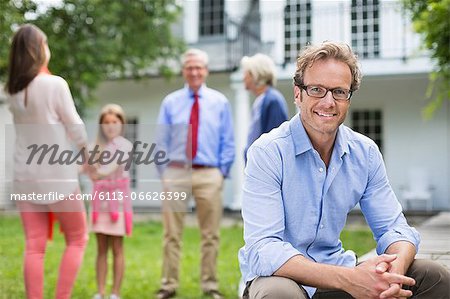 Man smiling outside house