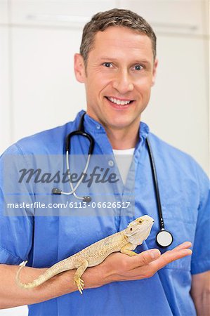 Smiling veterinarian holding lizard in vet's surgery