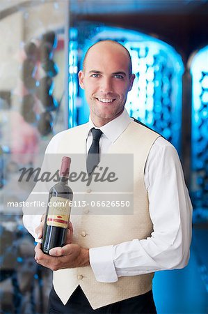 Waiter holding bottle of wine in restaurant