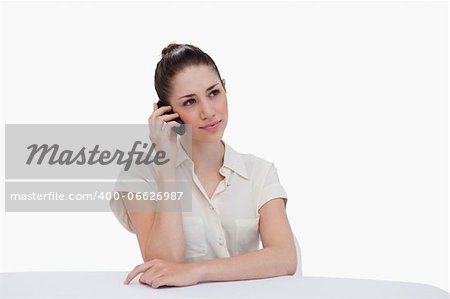 Young businesswoman making a phone call against a white background