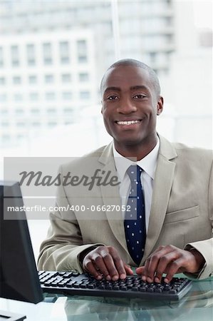 Portrait of a cheerful office worker using a computer in his office