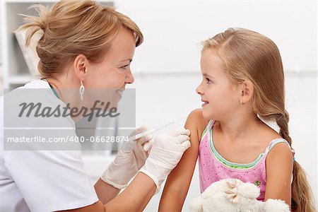 Brave little girl receiving injection or vaccine with a smile