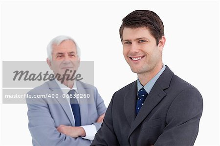 Close up of smiling businessman with his mentor behind him against a white background