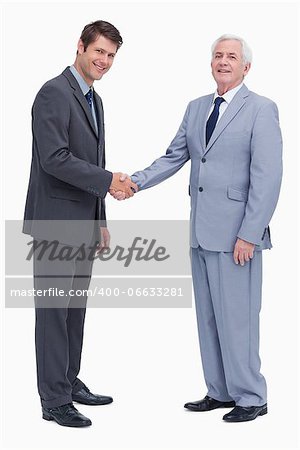 Side view of businessmen shaking hands against a white background