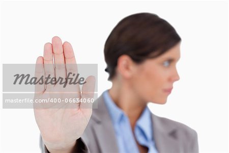 Close up of female entrepreneurs hand signalizing stop against a white background