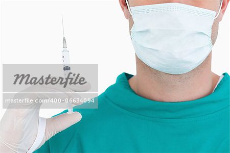 Close up of doctor with syringe wearing scrubs against a white background