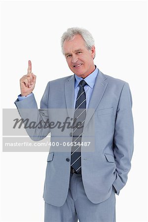 Smiling mature tradesman pointing up against a white background