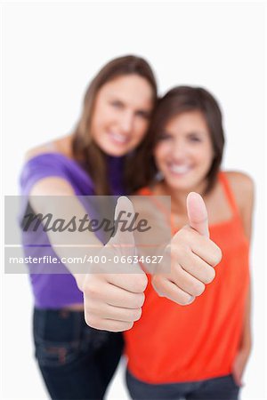 Thumbs up being showed by teens with focus on their thumbs