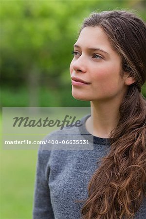 Thoughtful young girl looking towards the side while standing in the countryside