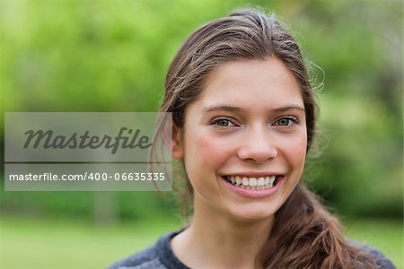 Young woman looking at the camera while showing a beaming smile