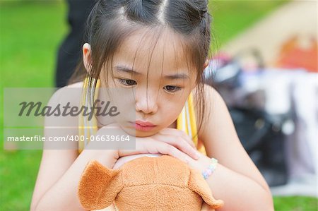 Outdoor upset Asian child. Little girl showing her unhappy face.