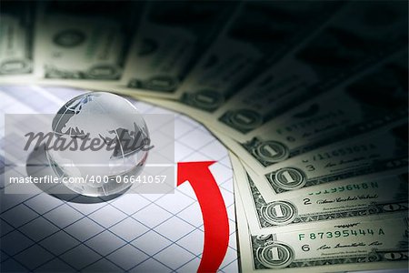 Business concept. Glass globe on paper background with chart and money