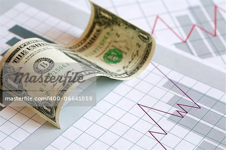 Business concept. Curved one dollar bill on paper background with business chart