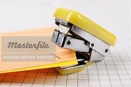 Two colorful sheets of paper stapled by the stapler