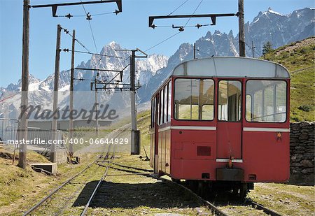 View of rail and coach with mountains in background.