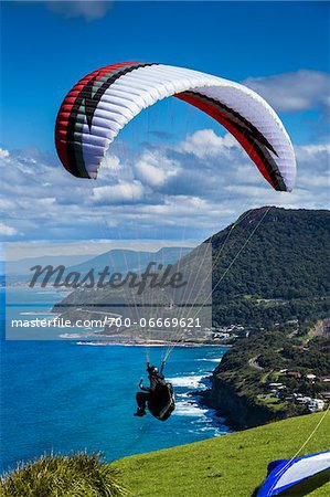 Paraglider taking off from cliff, looking south towards Wollongong from Bald Hill Lookout, Bald Hill Headland Reserve, Illawarra, Wollongong, New South Wales, Australia