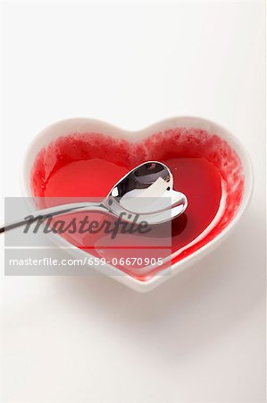 An empty heart-shaped bowl with a heart-shaped spoon