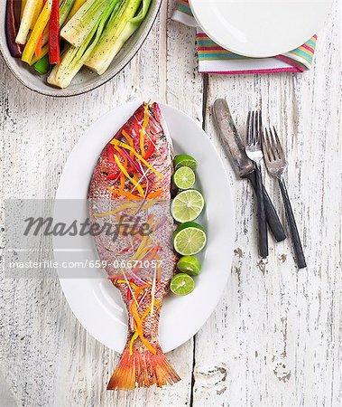 Whole Cooked Snapper Garnished with Shaved Vegetables and Limes; From Above