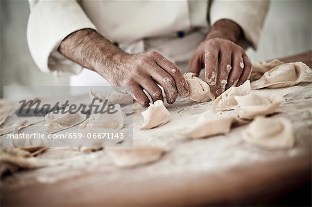 A chef rolling fresh tortellini in flour A chef rolling fresh tortellini in flour